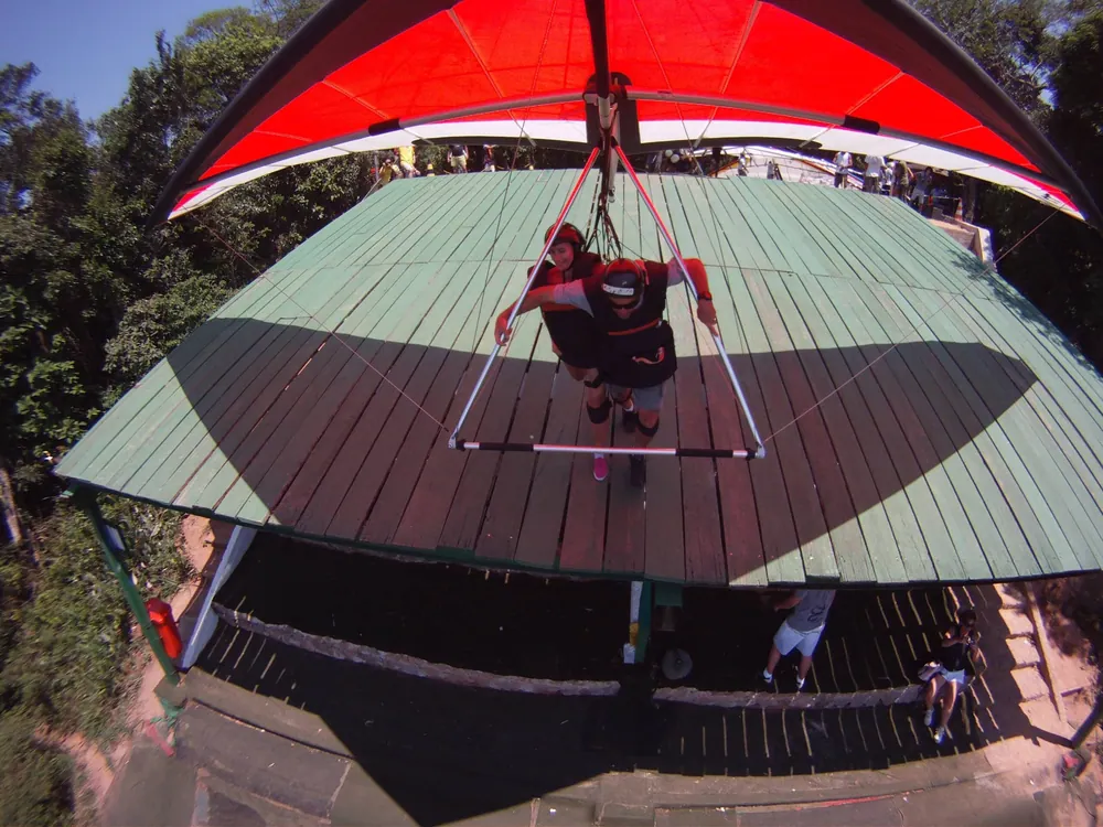 Hang glider launching from Pedra Bonita, the operator-identified Rio launch site; representative operator-site activity image, not independently confirmed as a specific customer tour.