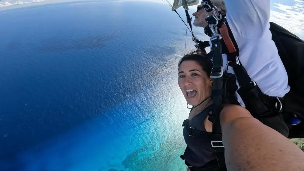 在加勒比海上空的双人降落伞下降，显示于 Skydive Playa 官方网站画廊。